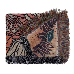 Detailed knit texture and floral rose pattern on outdoor picnic blanket with tassels
