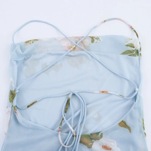 Détail de mini robe fleurie dos nu avec bretelles spaghetti et tissu en résille