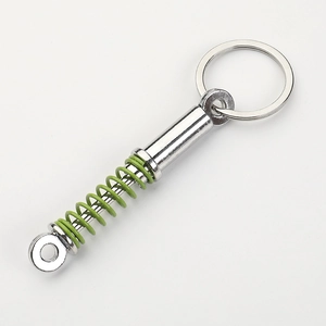 Car shock absorber keychain with silver metal finish and green spiral spring pendant
