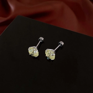 Detailed view of yellow zircon stud earrings with silver four-claw setting on silk fabric