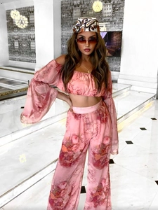 Pink floral two-piece set featuring off-shoulder long sleeve top and wide-leg trousers