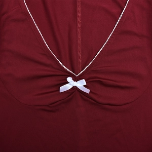 Close-up of the V-neckline featuring white piping and a small decorative bow on a red dress