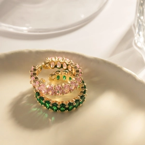 Elegant gold open ring set with green and pink oval zircon in a ceramic dish
