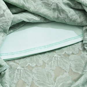 Close-up of mint green lace fabric detail and smooth matching lining for women's dress