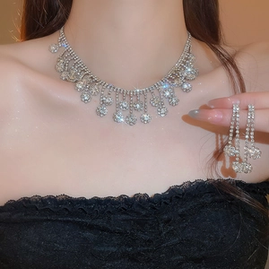 Macro view of crystal flower tassel necklace and earrings set on model with silver base