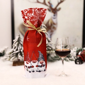 Christmas gnome wine bottle cover in red faux linen with snowflake prints and golden ribbon
