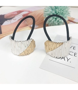 Macro detail of arc-shaped bicolored alloy hair tie with striped texture