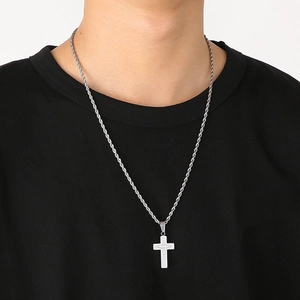 Silver cross pendant necklace with four-pointed star on a twisted rope chain worn by a model
