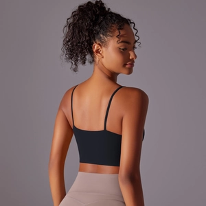 Detail view of black yoga tank top with thin straps and open back design on model