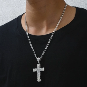 Close-up of sparkling silver cross pendant with iced out rhinestones on Cuban link chain