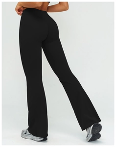 Close-up of black high-waisted flared yoga pants showing the back and side fit on model