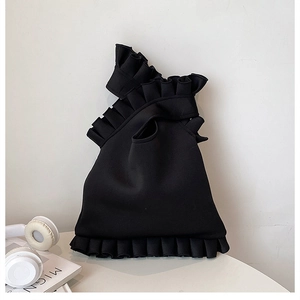 Detail of black ruffled shoulder bag with pleat design for a trendy minimalist look