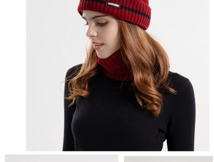 Dettaglio del set berretto in maglia rosso scuro e scaldacollo con etichetta del marchio