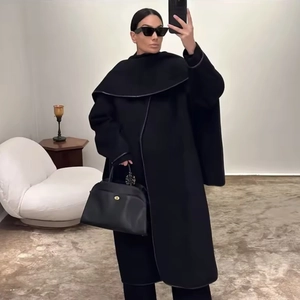 Minimalist black oversized wool coat with scarf detail shown in a full-length mirror selfie