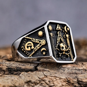 Detailed close-up of a two-tone steel skull ring with vintage masonic symbols