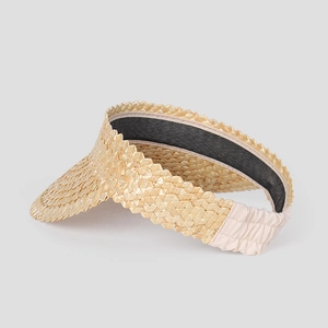 Detail of hand-woven wheat straw sun visor with zigzag edges and elastic back strap