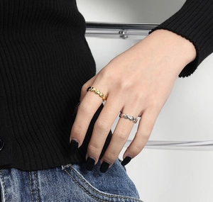Detailed view of silver and gold heart-shaped rings on model's fingers