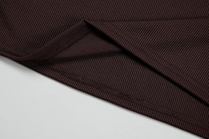 Close-up of dark brown ribbed knit fabric with precise double-needle stitching detail