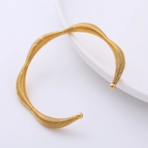 Minimalist 18K gold plated irregular wave cuff bracelet with spiral texture on white plate