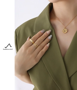 Detail of celestial sun and moon pendant necklace on olive blazer for a stylish look