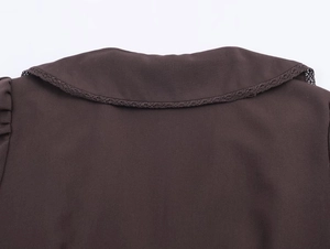 Detailed macro view of dark brown shirt collar with delicate hollow lace edge trim