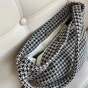 Close-up of houndstooth shoulder bag interior featuring magnetic snap closures