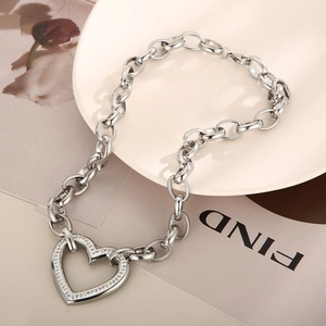 Macro view of silver chunky chain necklace with a diamond-studded heart pendant