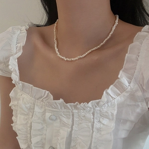 Close-up of irregular baroque freshwater pearl necklace worn on a female neck
