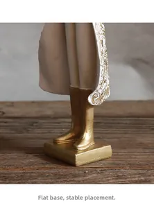 Dettaglio della base dorata stabile e della veste della scultura coniglio in resina