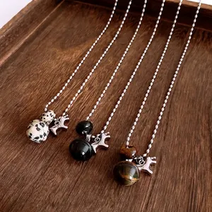 Tiger eye and onyx beaded horse pendant necklaces displayed on a wooden tray