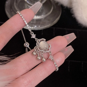 Detailed macro of a silver moon pendant bracelet with opal stone and adjustable chain