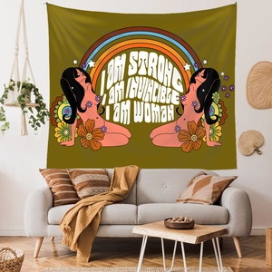 Detail view of feminist tapestry with retro floral art and motivational quote on a home wall