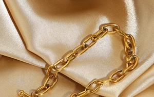 Detail of gold-plated stainless steel paperclip chain with OT toggle on silk fabric