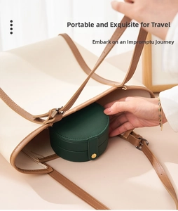 Placing a compact dark green jewelry travel case into a tote bag for portability