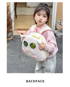 Detailed back view of cute pink cat eggshell backpack worn by a young child model