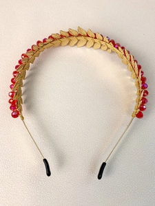 Close-up of handmade gold leaf headband with red crystal beads and metallic wire detail