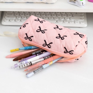 Detailed view of pink quilted pencil case with bow prints and stationery storage