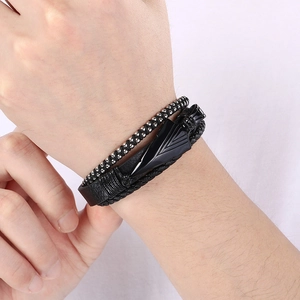 Dettaglio del bracciale multistrato da uomo in pelle nera con freccia e perline