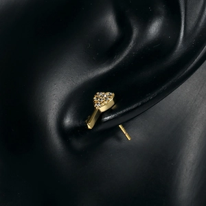 Elegant 18k gold heart-shaped stud earring with cubic zirconia on a black model ear