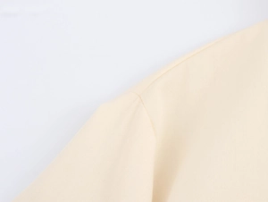 Detailaufnahme des beigefarbenen Baumwoll-Leinen-Stoffs mit feiner Stickerei und Textur