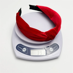 Close-up of a red velvet knotted headband on a digital scale showing weight of 39.3g