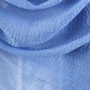 Close-up of light blue crinkle cotton linen fabric showing soft texture and mesh weave