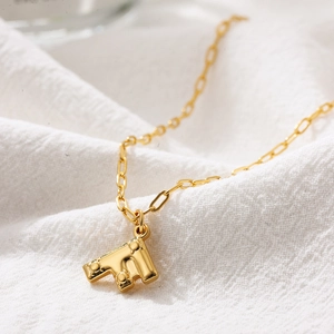 Macro shot of gold-plated letter F necklace pendant with signature metal studs