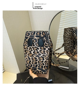 Detail view of the coffin-shaped leopard print crossbody bag with metallic zipper and strap