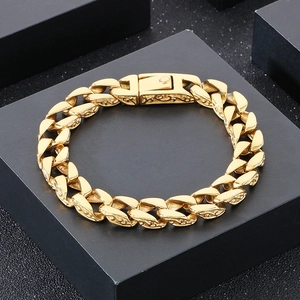 Detailed close-up of golden Cuban link bracelet featuring vintage engraved floral patterns