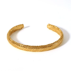 Detail of 18K gold plated knot bangle showing retro braided texture and polished finish