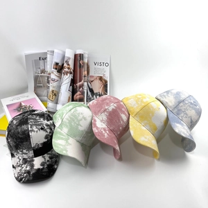 Détail de casquettes de baseball tie-dye en noir, vert, rose, jaune et bleu alignées