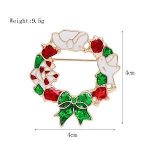 Detailed view of a 4cm Christmas wreath brooch with red and green enamel and gold finish