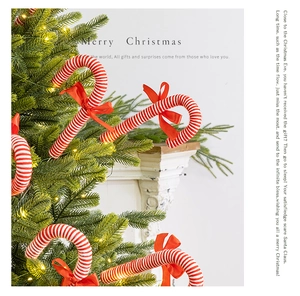 Macro shot of red and white candy cane with a red bow on a festive Christmas tree