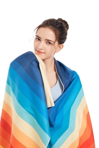 Detail of microfiber beach towel showing vibrant rainbow stripes and durable hemmed edges